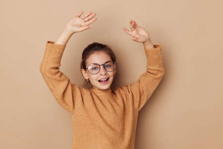 little girl with glasses emotions gesture hands isolated backgroundの写真素材