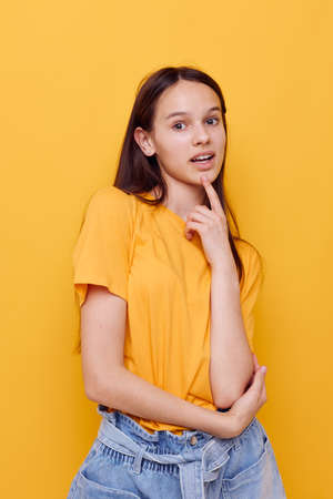 attractive woman in a yellow t-shirt emotions summer style isolated backgroundの写真素材