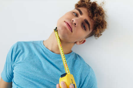 Attractive man blue t-shirt measuring tape posing Lifestyle unaltered