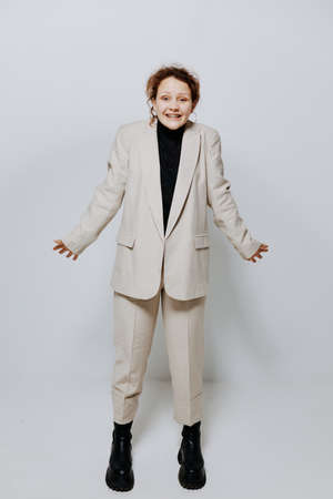 beautiful woman In a light classic suit posing emotions yellow background unalteredの写真素材