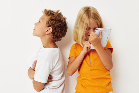 two joyful children stand next to notepad pencil drawing emotions lifestyle unalteredの写真素材