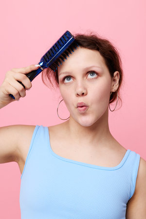teenager girl removes hair on a comb dissatisfaction isolated background unalteredの写真素材