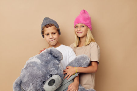 Boy and girl in hats with a teddy bear friendship Lifestyle unaltered