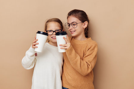 little girls hugging together glass with drinkの写真素材