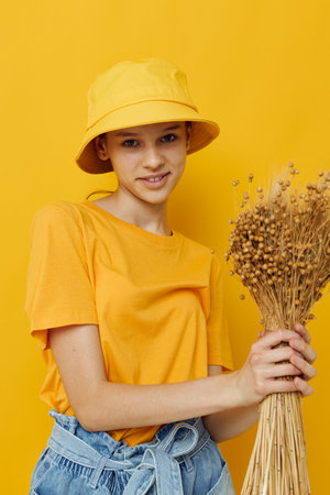 young woman a bouquet of dried flowers in hands Youth style casual wear in Hat
