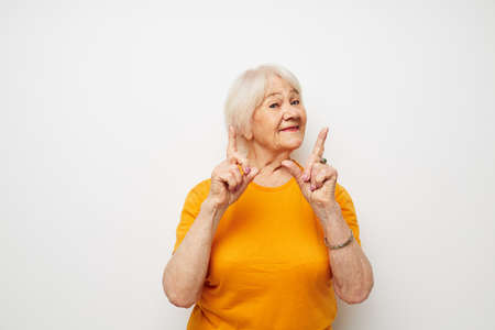 Photo of retired old lady in a yellow t-shirt posing close-up emotions