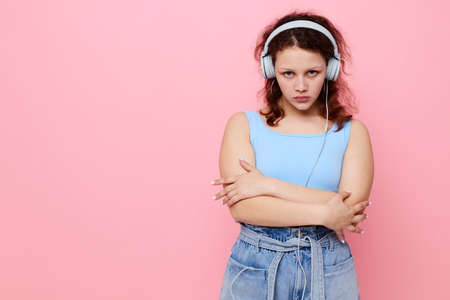 cheerful girl in headphones in youth style posing pink background unalteredの写真素材