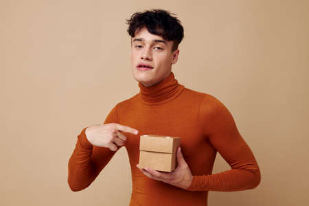 Photo young boyfriend stylish hairstyle brown turtleneck small box in hand Lifestyle unalteredの写真素材