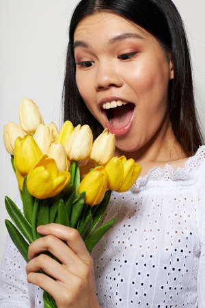 Charming young Asian woman with a bouquet of flowers smile close-up Lifestyle unalteredの写真素材