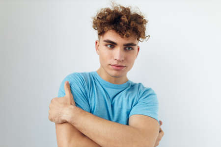 handsome man with curly hair in a blue t-shirtの写真素材