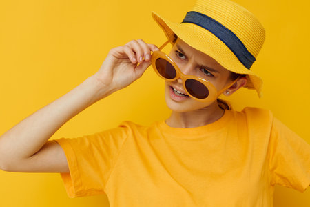 optimistic young woman in a yellow hat Youth style casual wear in sunglasses Lifestyle unalteredの写真素材