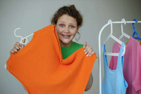 beautiful woman trying on clothes wardrobe Youth style yellow background unalteredの写真素材