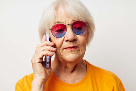 Photo of retired old lady happy lifestyle in yellow t-shirts isolated backgroundの写真素材