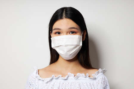 Portrait Asian beautiful young woman medical mask on the head protection studio model unalteredの写真素材