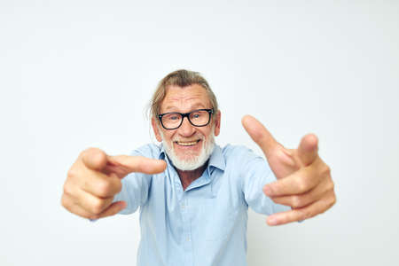 Portrait elderly man in blue shirts gestures with his hands isolated backgroundの写真素材