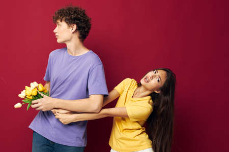 cute young couple a bouquet of yellow flowers based friendship isolated background unalteredの写真素材