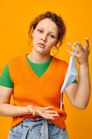 pretty girl protective medical mask fun posing fashion pink background unalteredの写真素材