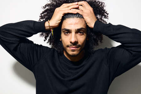 man with curly hair in a black sweater hand gesture Lifestyle unaltered