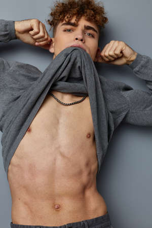 kinky guy in a gray sweatshirt fashion studio isolated backgroundの写真素材