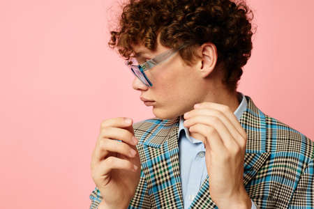 cute red-haired guy folder for papers blank sheet posing in suit pink background unalteredの写真素材