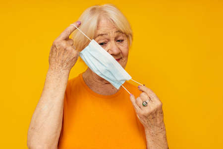smiling elderly woman in yellow t-shirts in medical masks close-up emotions