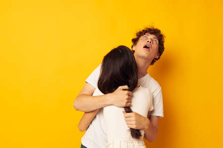 cute young couple stand hugging each other in white T-shirts isolated background unaltered