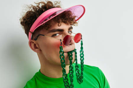 handsome young man stylish glasses cap close-up isolated backgroundの写真素材