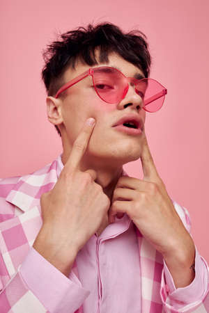 Photo of romantic young boyfriend fashionable pink sunglasses jacket posing model studioの写真素材