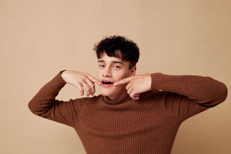 A young man brown turtleneck posing fashion light background unaltered