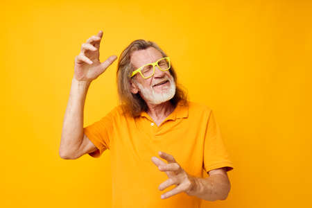 Senior grey-haired man hand gestures emotions yellow glasses monochrome shotの写真素材