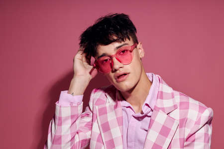 Photo of romantic young boyfriend in pink glasses pink blazer posing studio pink background unalteredの写真素材