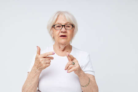 Portrait of an old friendly woman vision problems with glasses light backgroundの写真素材