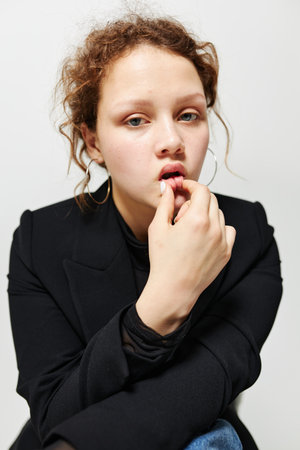 portrait of a young woman elegant style black blazer posing light background unaltered