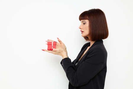 portrait of a woman with gift small box in a leather suit black jacket Lifestyle unalteredの写真素材