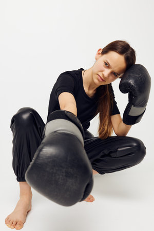 athletic woman boxing black gloves posing sports light background