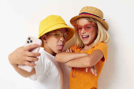 funny kids posing selfie with phone fashionの写真素材