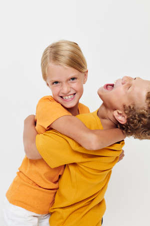 picture of positive boy and girl in yellow t-shirts standing side by side childhood emotions...
