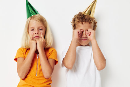 Portrait of cute children with caps on his head holiday entertainment light backgroundの写真素材