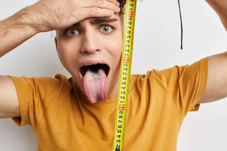 kinky guy grimace measuring tape posing isolated backgroundの写真素材