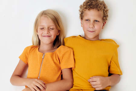 funny kids boy and girl in yellow t-shirts Studio light background