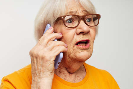 elderly woman happy lifestyle in yellow t-shirts close-up emotionsの写真素材