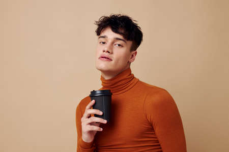 Photo young boyfriend stylish hairstyle brown turtleneck black disposable cup Lifestyle unalteredの写真素材