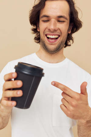 handsome man in a white T-shirt with a black glass in hand Lifestyle unalteredの写真素材