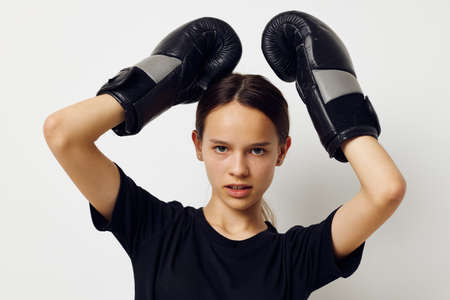 beautiful girl in black sports uniform boxing gloves posing Lifestyle unalteredの写真素材