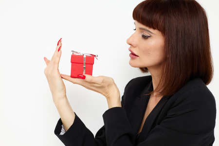 attractive woman with gift small box in a leather suit black jacket isolated background