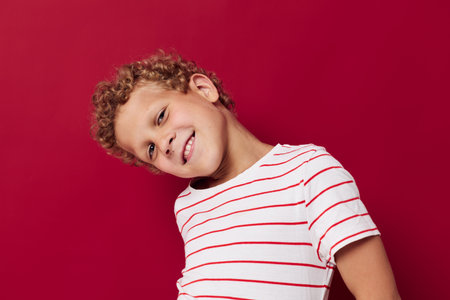 cute boy with curly hair in striped t-shirt emotionsの写真素材