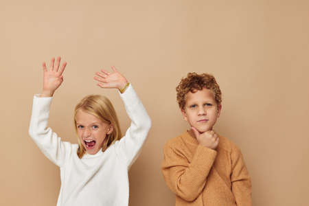 Boy and girl standing next to posing emotions Lifestyle unalteredの写真素材