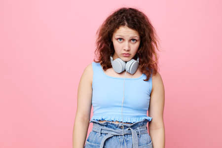 cute girl wearing headphones stylish youth clothing pink backgroundの写真素材