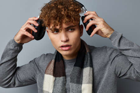 Attractive man plaid scarf wireless headphones technology isolated backgroundの写真素材