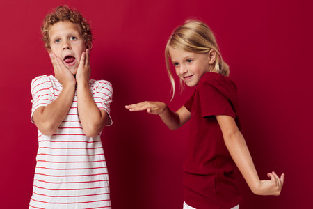 Boy and girl smiling and posing in casual clothes against on colored backgroundの写真素材